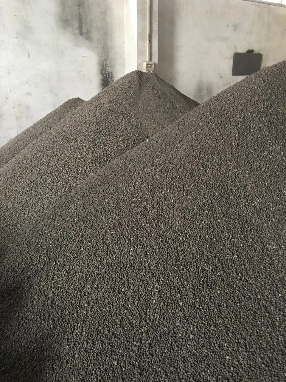 Agrosin kapalı depoda dökme granül gübre yığınları