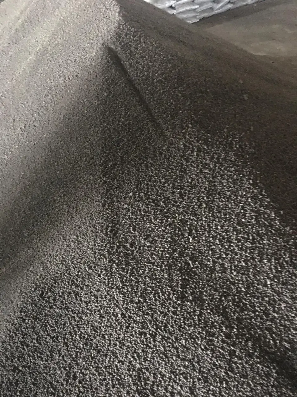 Agrosin çuvallama öncesi granül gübre yığını, arka planda paketli ürün